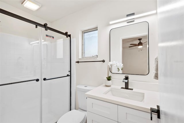 bathroom with a shower with door, vanity, and toilet