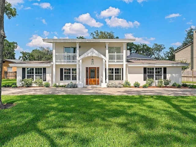 view of front facade featuring a balcony and a front yard