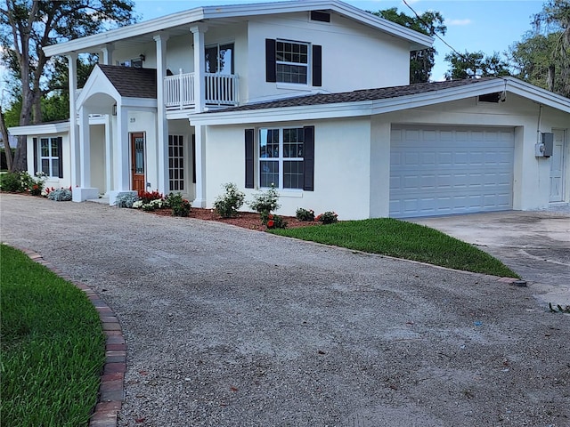 view of front of property featuring a balcony and a garage