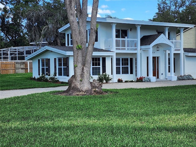 view of front of house with a front yard and a balcony