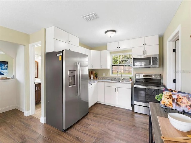 219 Nob Hill Cir, Longwood, FL 32779 - kitchen with white cabinets, a sink, dark wood-style flooring, visible vents, and appliances with stainless steel finishes