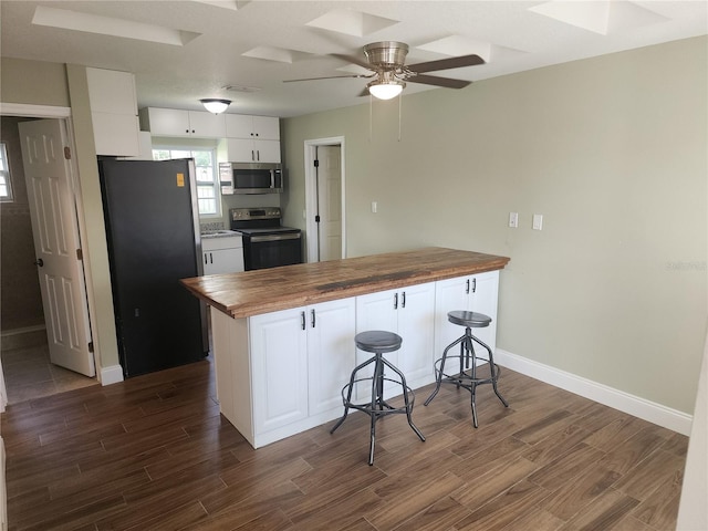 219 Nob Hill Cir, Longwood, FL 32779 - kitchen featuring dark wood-type flooring, a peninsula, wood counters, a kitchen bar, and appliances with stainless steel finishes