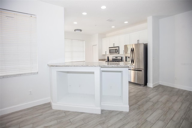 kitchen with white cabinetry, appliances with stainless steel finishes, and kitchen peninsula