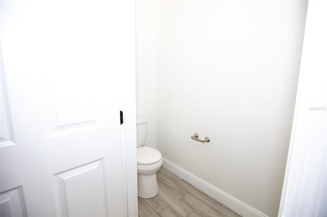 bathroom featuring hardwood / wood-style flooring and toilet