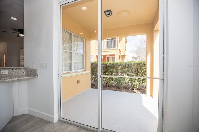 doorway to outside featuring plenty of natural light, ceiling fan, and light hardwood / wood-style flooring