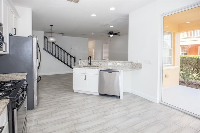 kitchen with white cabinetry, sink, black range with gas stovetop, stainless steel dishwasher, and light stone countertops