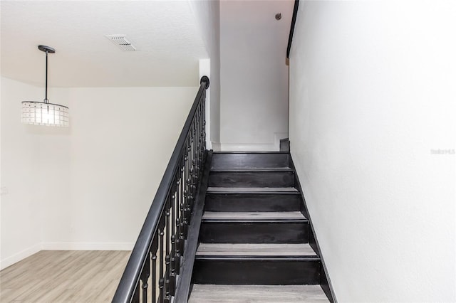 staircase with hardwood / wood-style floors