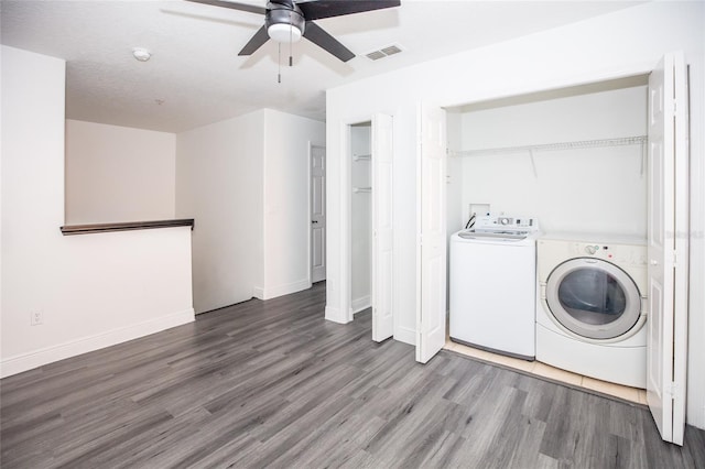 clothes washing area featuring ceiling fan, wood-type flooring, and washing machine and dryer