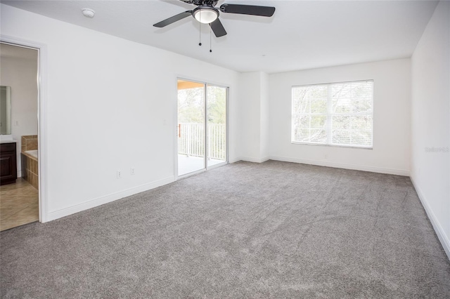 carpeted spare room featuring ceiling fan