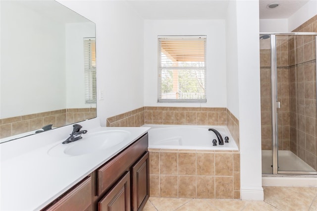 bathroom featuring tile patterned flooring, shower with separate bathtub, and vanity