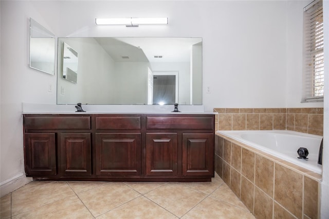 bathroom featuring tile patterned floors, vanity, and tiled tub