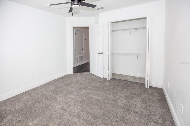 unfurnished bedroom featuring dark colored carpet, ceiling fan, and a closet