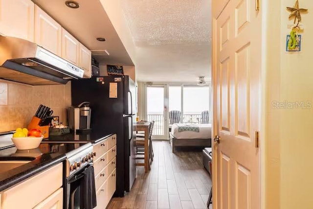 kitchen with white cabinetry, backsplash, high end stove, a textured ceiling, and dark hardwood / wood-style flooring