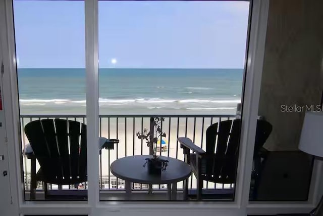 balcony with a water view and a beach view