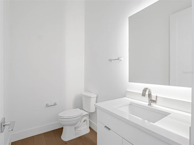 bathroom with vanity, toilet, and wood-type flooring