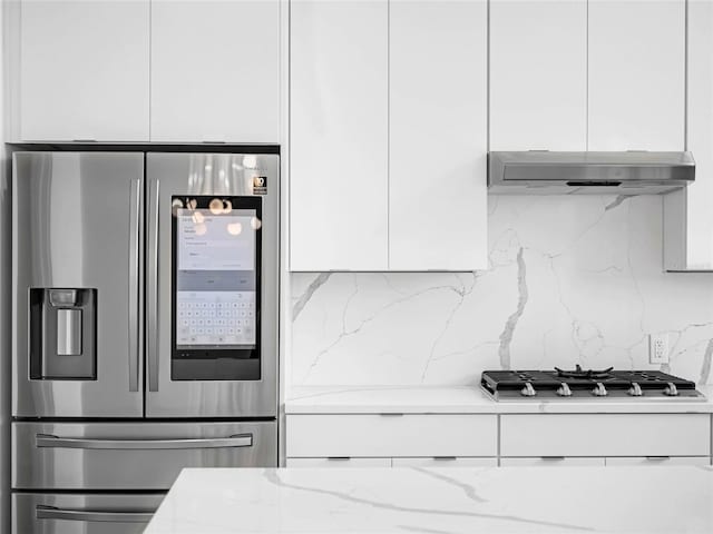 kitchen with light stone counters, mail boxes, stainless steel appliances, and white cabinets