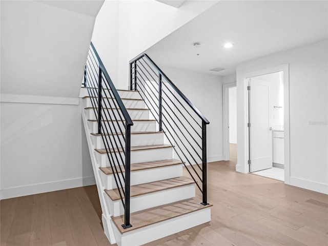 stairs featuring hardwood / wood-style floors