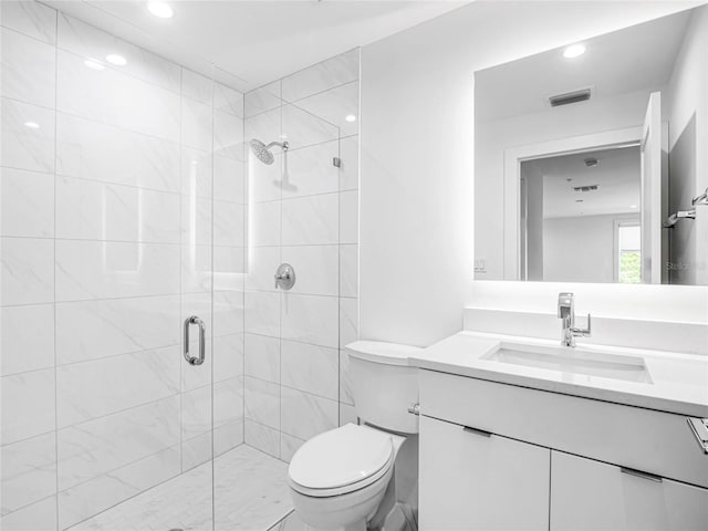 bathroom featuring vanity, an enclosed shower, and toilet