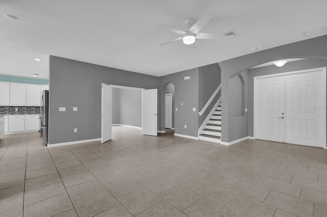 unfurnished living room featuring light tile patterned floors and ceiling fan