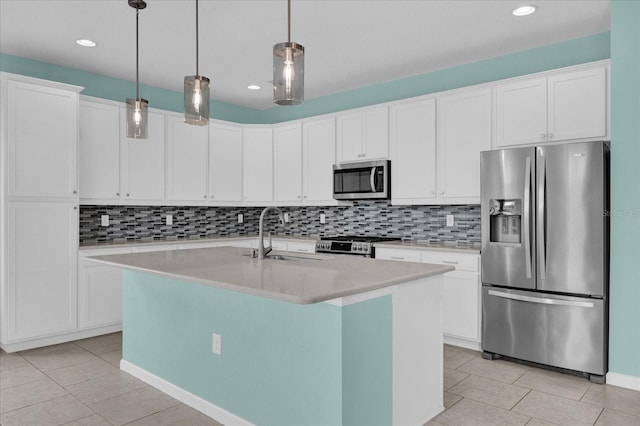 kitchen with sink, decorative light fixtures, a center island with sink, appliances with stainless steel finishes, and white cabinets