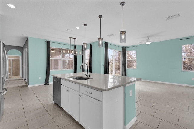 kitchen with sink, appliances with stainless steel finishes, white cabinetry, a center island with sink, and decorative light fixtures