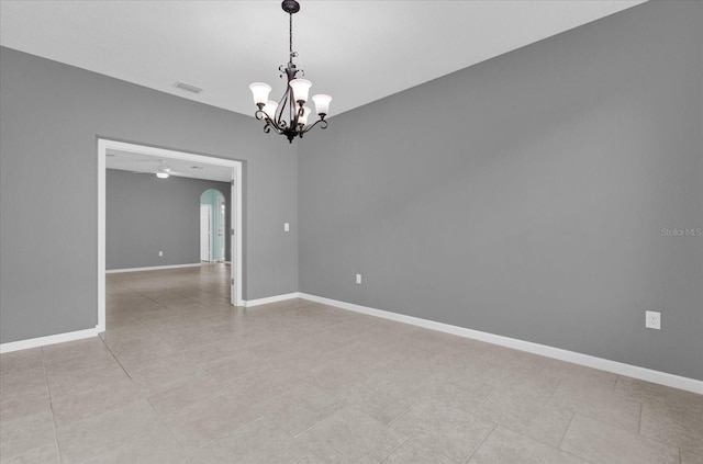 spare room featuring ceiling fan with notable chandelier