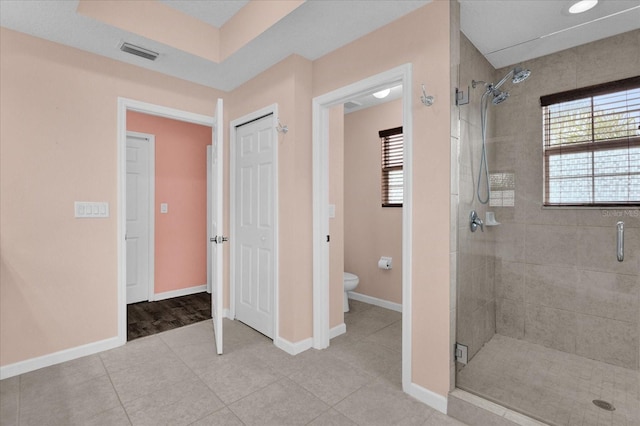 bathroom featuring tile patterned floors, toilet, and an enclosed shower