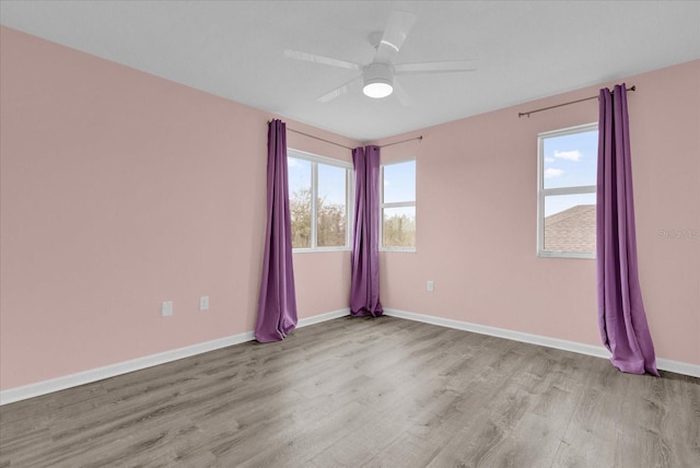 empty room with ceiling fan and light hardwood / wood-style floors