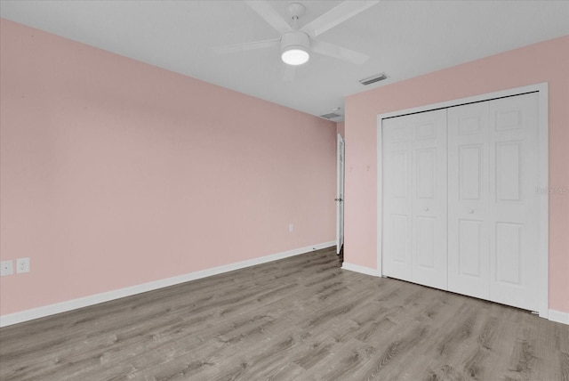 unfurnished bedroom with ceiling fan, a closet, and light hardwood / wood-style flooring