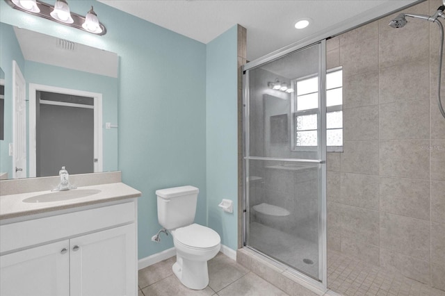 bathroom with vanity, toilet, a shower with shower door, and tile patterned flooring