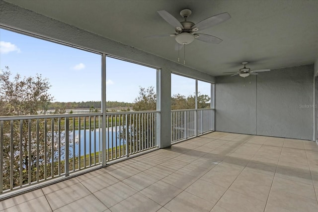 unfurnished sunroom featuring a water view and ceiling fan