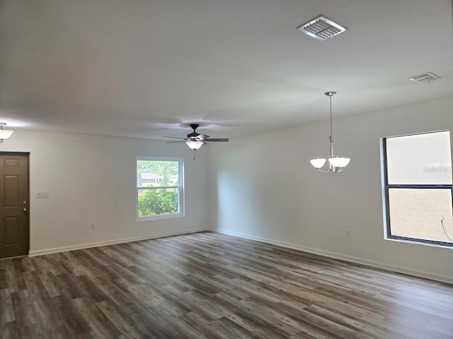 empty room featuring dark hardwood / wood-style floors and ceiling fan with notable chandelier