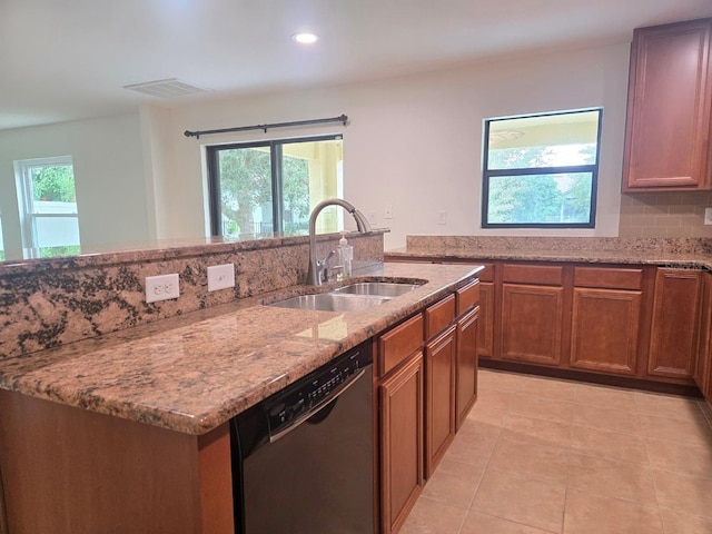 kitchen featuring sink, a wealth of natural light, light stone countertops, and black dishwasher