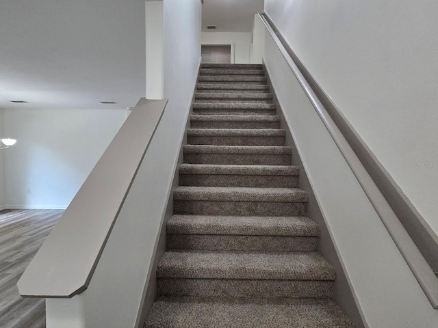 stairs featuring hardwood / wood-style flooring