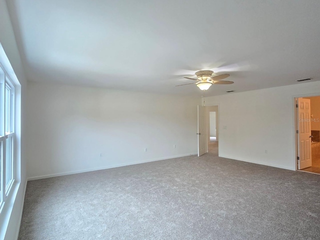 carpeted spare room featuring ceiling fan