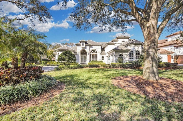 mediterranean / spanish home with a front yard