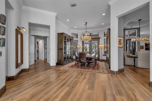 unfurnished dining area with an inviting chandelier, hardwood / wood-style flooring, and ornamental molding