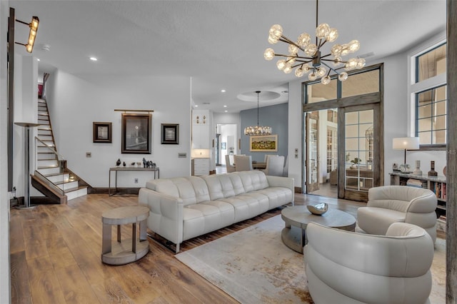 living room with hardwood / wood-style floors, a textured ceiling, and a notable chandelier