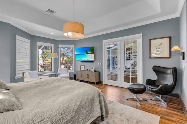 bedroom featuring french doors, ornamental molding, a raised ceiling, hardwood / wood-style flooring, and access to exterior