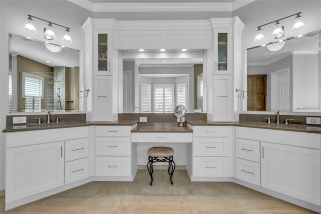 bathroom featuring ornamental molding, a healthy amount of sunlight, and vanity