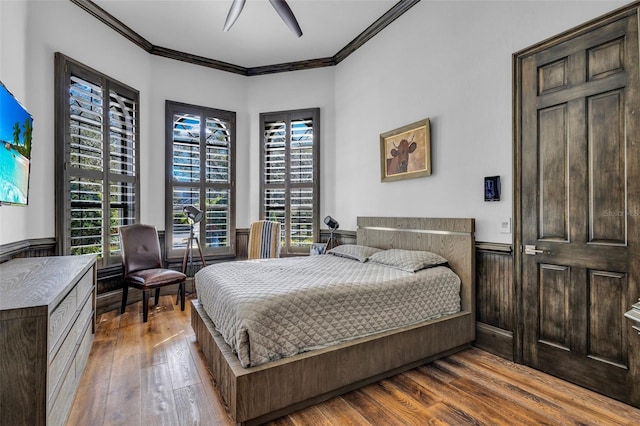 bedroom with crown molding, ceiling fan, and wood-type flooring