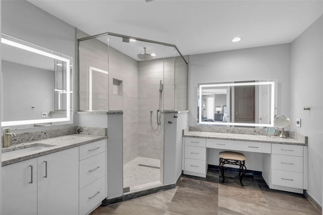 bathroom with vanity and a shower with door