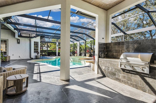 view of swimming pool featuring a patio, glass enclosure, a grill, an outdoor kitchen, and an in ground hot tub