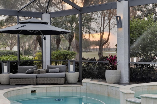 pool at dusk with a hot tub