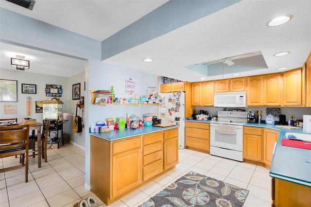 kitchen with light tile patterned floors, white appliances, and a raised ceiling