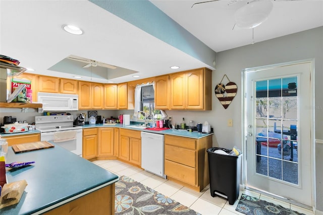 kitchen with sink, white appliances, light tile patterned floors, ceiling fan, and a tray ceiling