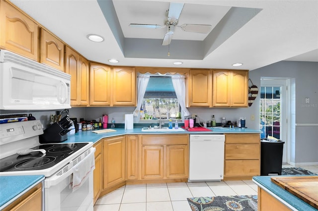 kitchen featuring sink, white appliances, light tile patterned floors, a tray ceiling, and ceiling fan