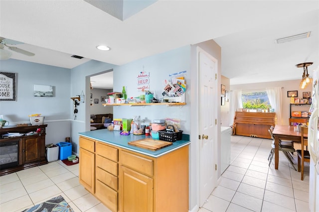 kitchen featuring light brown cabinets, ceiling fan, and light tile patterned floors