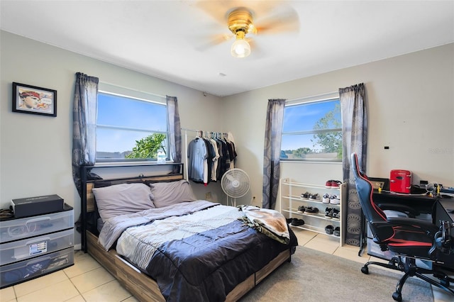 bedroom with multiple windows, light tile patterned floors, and ceiling fan