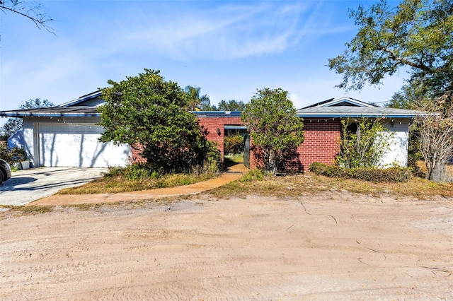 view of property hidden behind natural elements featuring a garage